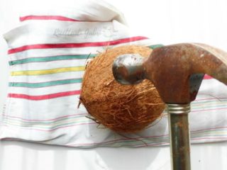 Aprire il cocco con un martello dopo averlo uscito dal forno